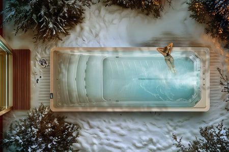 Obenansicht eines Exercise Swim Spas im Winter mit einer Frau, die im Wasser schwimmt.