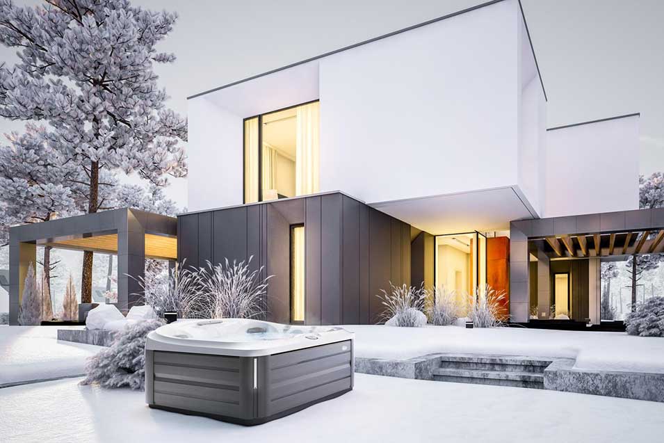 Jacuzzi Spa Whirlpool in winterlicher Landschaft vor moderner Architektur mit klaren Linien.