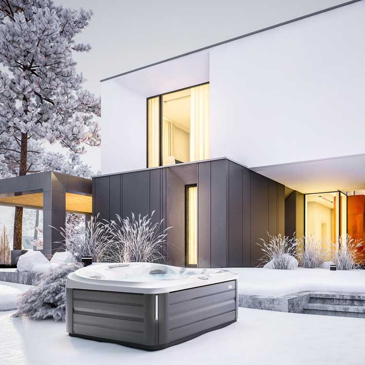 Jacuzzi Spa Whirlpool in winterlicher Landschaft vor moderner Architektur mit klaren Linien.