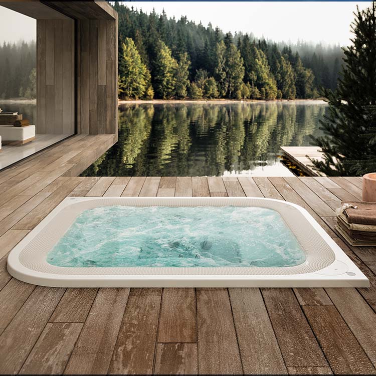 Jacuzzi Virtus Whirlpool mit Überlaufrinne auf einer Holzterrasse am See mit Naturkulisse.