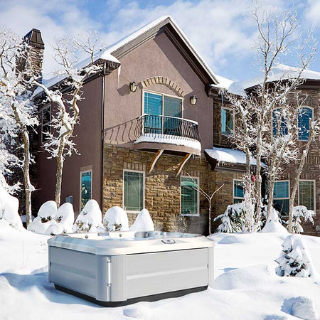 Jacuzzi Whirlpool Modell J-345 aus der J-300 Premium Serie in einer wunderschönen Winterlandschaft vor dem Haus.