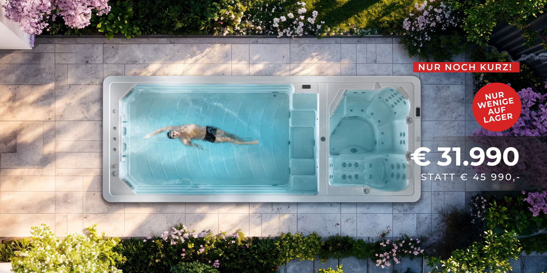 Mirna 60 Duo Swim Spa von oben mit Schwimmer im Wasser, umgeben von blühenden Pflanzen auf Steinfliesen.