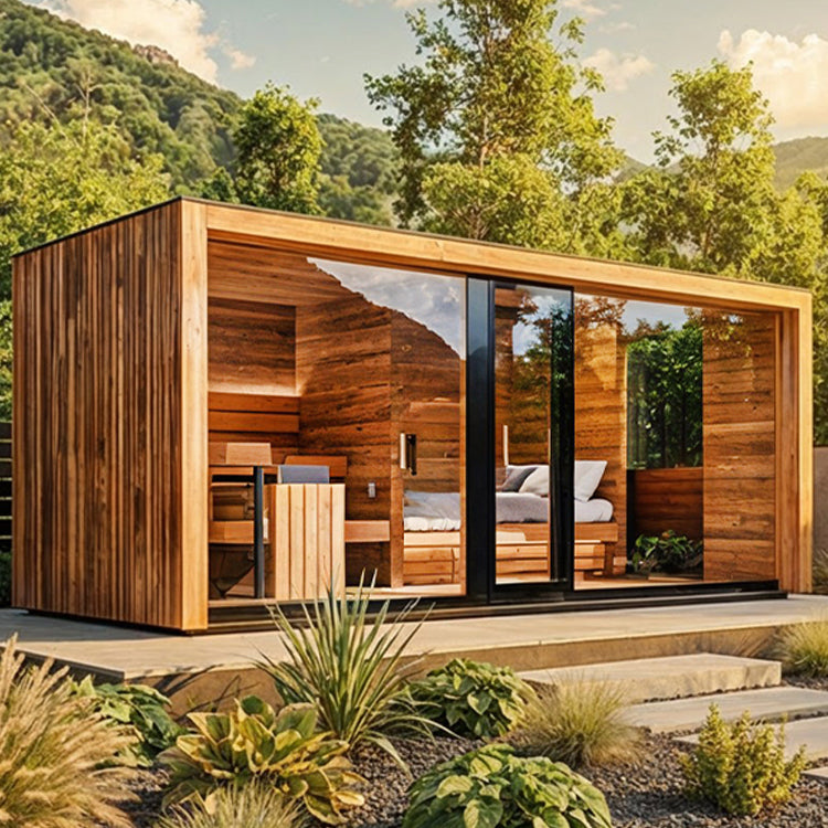 Moderne Gartesauna mit grosser Glasfront steht in einem Garten mit Grünpflanzen