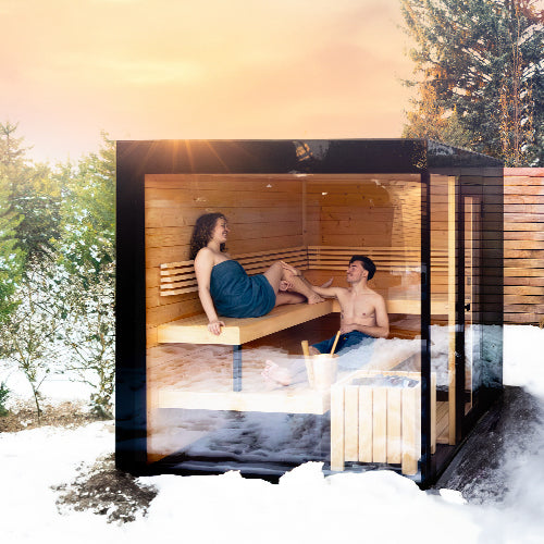 Ehepaar sitzt im Winter gemeinsam in der Gartensauna.