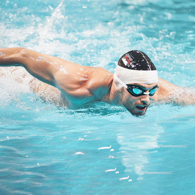 Sportlicher Schwimmer bei seinem intensiven Schwimmtraining im Swimmingpool gegen die Gegenstromanlage.