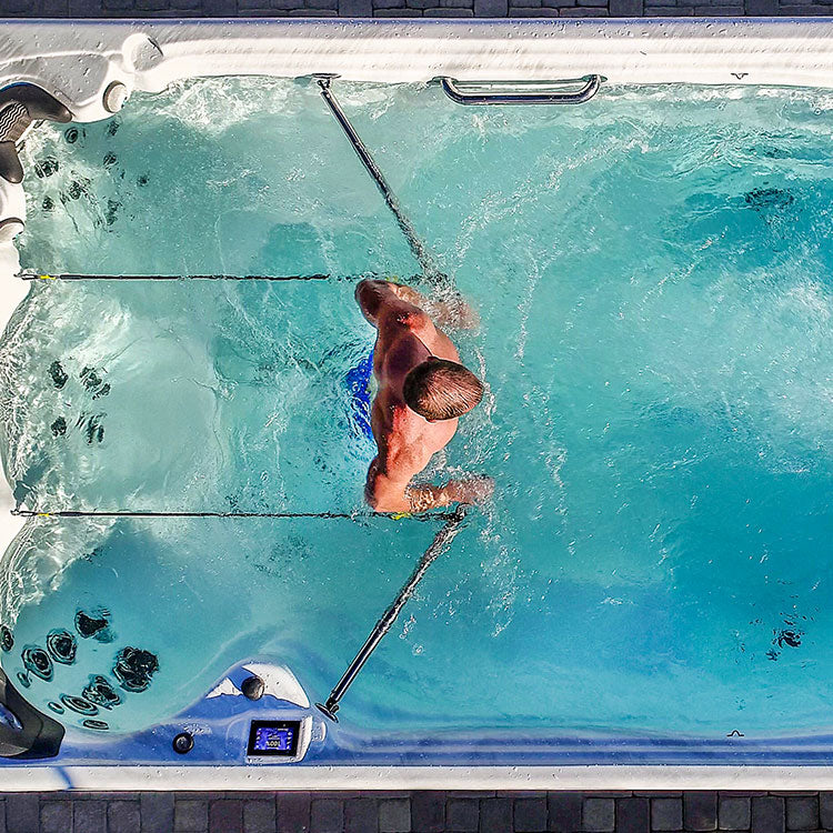 Obenansicht eines Swim Spas mit einem Mann, der Wassergymnastik macht.