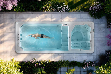 Obenansicht eines Whirl- & Swim Spas mit einem Mann, der im Wasser schwimmt.
