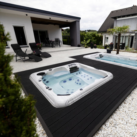 Bodeneben installierter Whirlpool in moderner Terrassenanlage mit überdachter Lounge und minimalistischer Architektur.