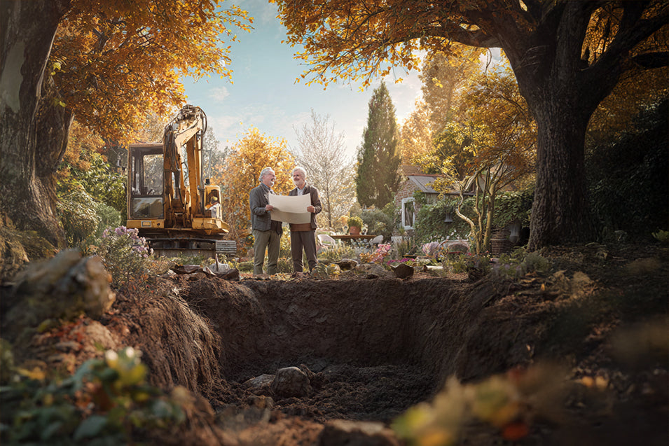 Zwei Männer stehen im herbstlich gefärbten Garten neben einem Bagger und besprechen Baupläne für den Whirlpool-Einbau. Im Vordergrund ist eine ausgehobene Grube sichtbar, umgeben von Bäumen und buntem Laub.